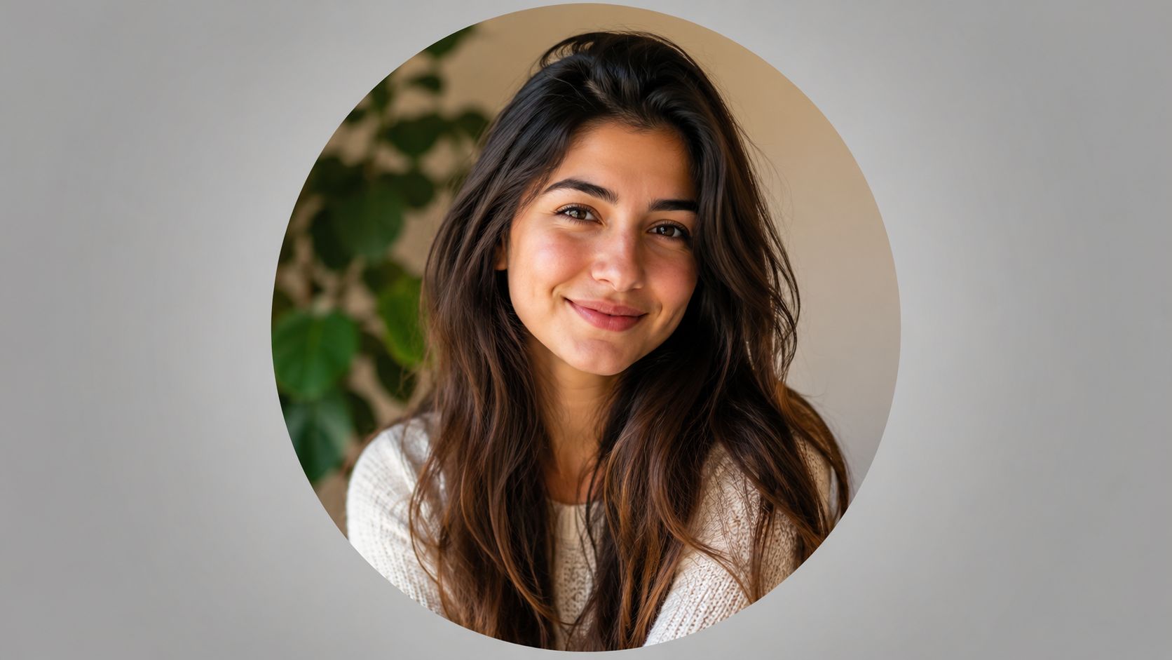 A friendly young woman with long wavy dark brown hair smiling at the camera, portrait format.