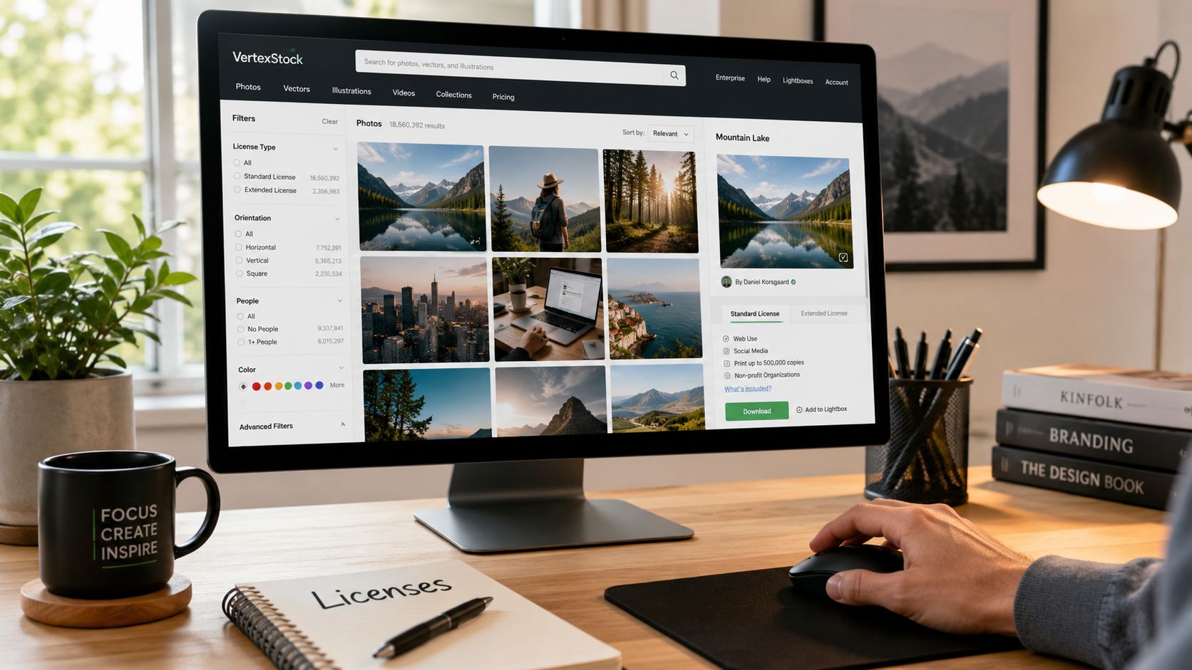 A person browsing a stock photography website on a desktop monitor in a modern home office setting.