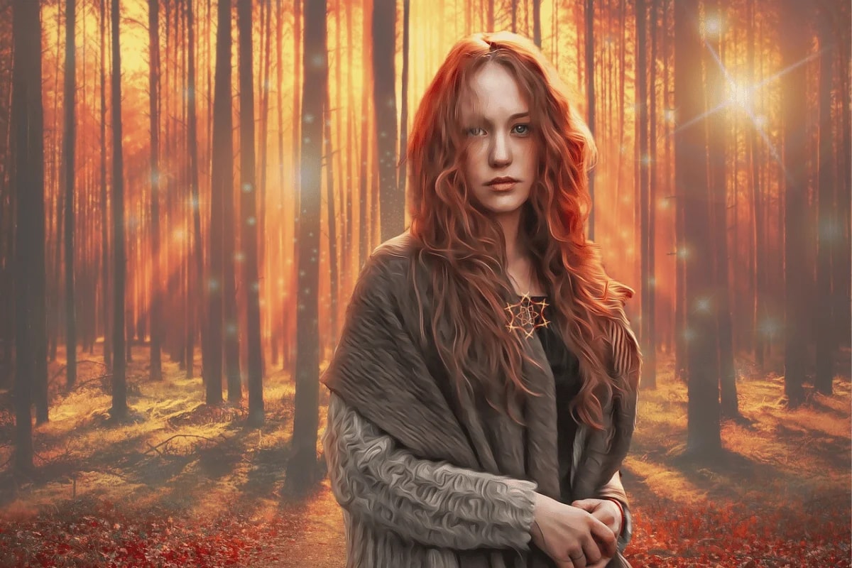 A woman with long, wavy red hair stands in a sunlit forest, wearing a cozy shawl and a star necklace, surrounded by autumn colors.